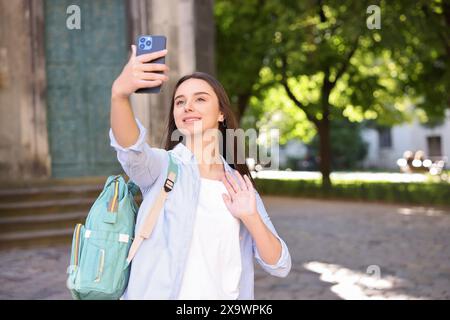 Beautiful travel blogger with smartphone streaming outdoors Stock Photo