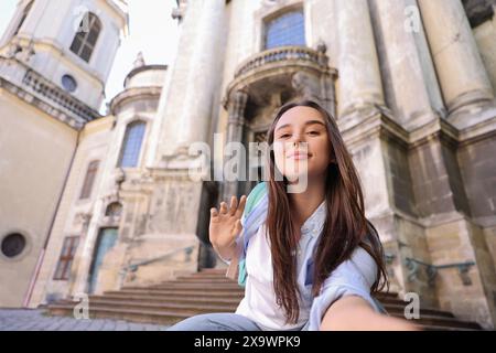 Beautiful travel blogger streaming outdoors, low angle view Stock Photo