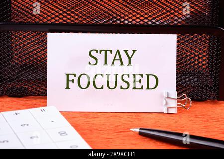 Concept words Stay focused written on the business card on the background of the stand Stock Photo