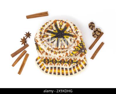 Flat lay photography of a fair Isle tweed wool knitted hat in white, yellow, orange and black on a white background with nature gifts decor Stock Photo