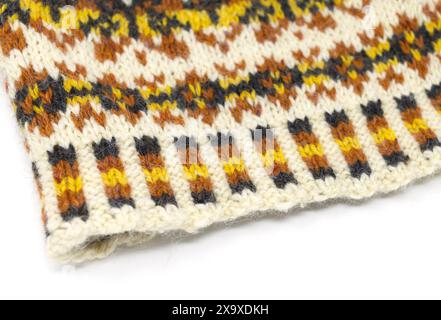 Close-up photography of a Fair Isle tweed wool knitted hat in white, yellow, orange and black, nordic beanie isolated on white background Stock Photo