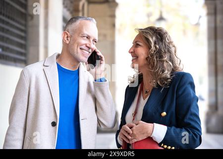 Happy friends or couples talking on smartphone outdoors. Stock Photo