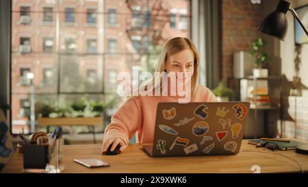 Attractive Young Woman Using Laptop Computer while Sitting in Stylish Cozy Living Room. Female Shopping Online from Home. Browsing Internet, Using Social Networks, Writing Project. Stock Photo