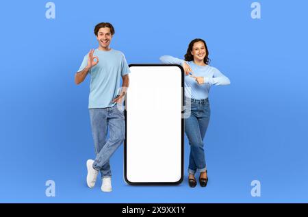 Smiling Man and Woman Next to Blank Phone Screen Stock Photo