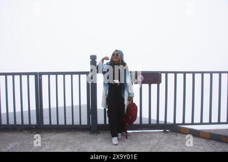 Thai women traveler people travel visit and posing portrait take photo with view landscape at cliff viewpoint of Tianmen Mountain National Forest Park Stock Photo