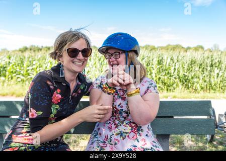 Down Syndrome woman connecting with her friends, both wearing a summer dress, Hakendover, Flanders, Belgium Stock Photo