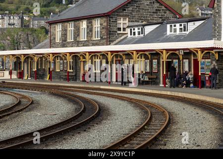 Passengers and a member of staff at Porthmadog station, Welsh Highland Heritage Railway. Porthmadog, Gwynedd, Wales Stock Photo