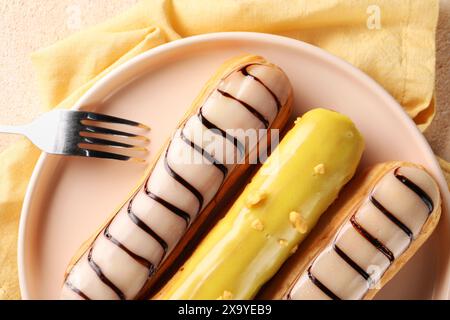 Different tasty glazed eclairs served on table, top view Stock Photo