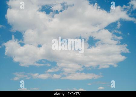 A scenic view of white fluffy clouds in the blue sky on a sunny day Stock Photo