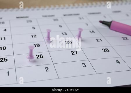 Timetable. Calendar page, drawing pins and felt pen on table, closeup Stock Photo