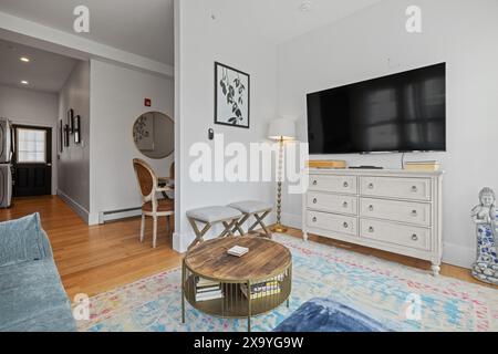 A spacious living room featuring a big screen TV and various decorations Stock Photo