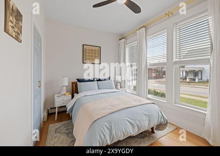 White walls and floors with hardwood flooring in master bedroom Stock Photo