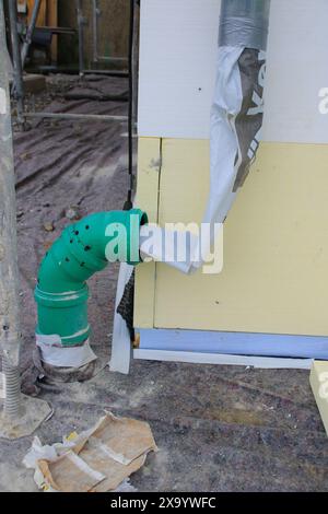 Water from a downspout is redirected using a hose Stock Photo