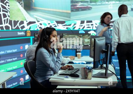 Indian woman employee offers order tracking updates in control center, managing complains from customers. Dispatch operator ensures faster cargo shipping with satellite navigation. Stock Photo