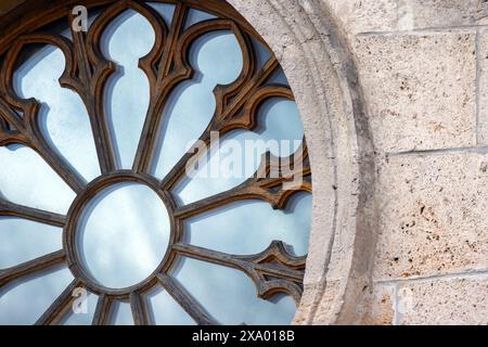 Fragment of round Gothic window with wooden frame in stone wall, abstract architecture background photo Stock Photo