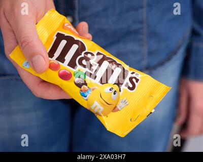 Tambov, Russian Federation - January 23, 2024  A woman holding out M&Ms pack Stock Photo