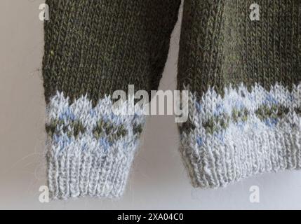 photography of an Icelandic knitted wool lopapeysa sweater cuffs in traditional Nordic knitting pattern, close-up for brown green grey pullover detail Stock Photo