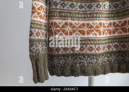 details of an Icelandic knitted wool lopapeysa sweater in traditional Nordic knitting pattern, close-up photo of brown green grey pullover pattern and Stock Photo
