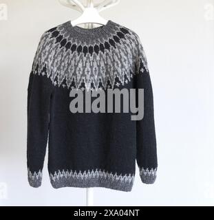 photo of an Icelandic knitted wool lopapeysa sweater with large grey and black yoke in traditional Nordic knitting pattern Stock Photo
