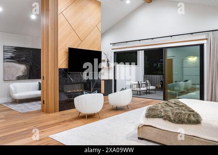 Contemporary white bedroom with wooden ceiling and glass sliding doors Stock Photo
