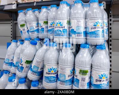 Italy - June 01, 2024: Parmalat milk with vitamin D in white plastic bottles packed in shelves for sale in italian discount supermarket Stock Photo