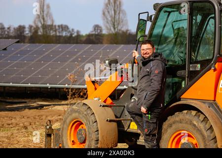 A construction worker installing solar panels in Germany Stock Photo