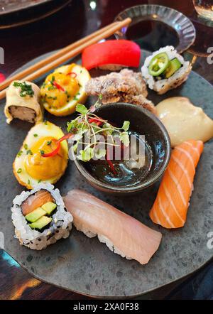 A plate with assorted sushi, sauce, and chopsticks Stock Photo