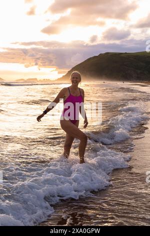 Europe, Spain, Gipuzkoa, Zarautz Beach with attractive older woman bathing at dawn Stock Photo