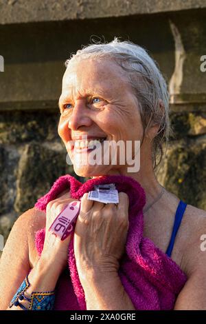 Europe, Spain, Gipuzkoa, Zarautz Beach with attractive Older Woman showering after her Swim Stock Photo