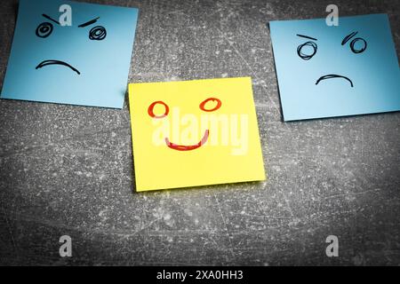 Sticky notes with smiley faces on grey background, closeup Stock Photo