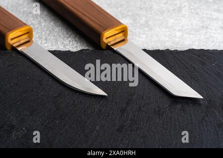 Two knives on black slate background. View from above. Copy space Stock Photo