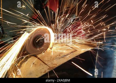 An individual operating a metal cutting machine in a manufacturing plant Stock Photo