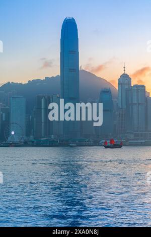 A Red Sail Junk in Hong Kong Harbour at Sunset, Hong Kong, Hong Kong Special Administrative Region of the People's Republic of China, People's Republi Stock Photo