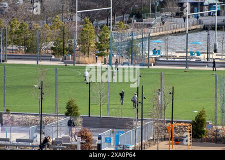 A group of people playing on a soccer field Stock Photo