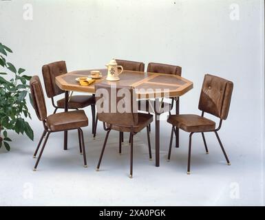 Vintage mid century dining set with octagonal wooden table, six brown vinyl chairs and retro tea service isolated on clean studio background Stock Photo