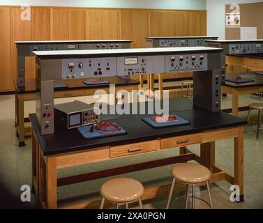 Vintage physics classroom laboratory with analog equipment, circuit boards, and wooden benches, showcasing mid-century science education setting. Stock Photo