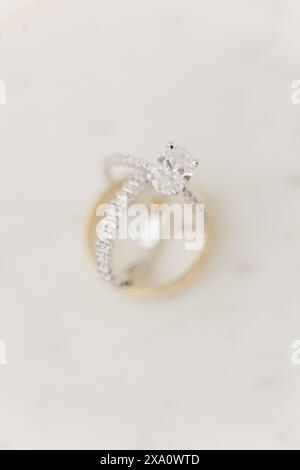 Diamond wedding and engagement rings displayed on a white surface Stock Photo