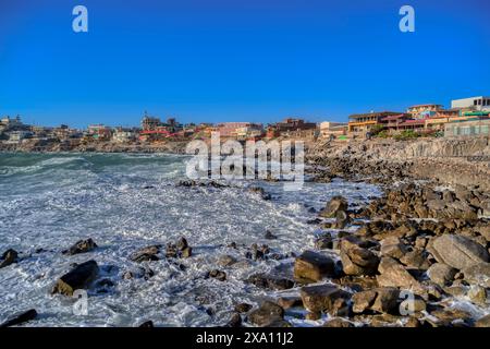 Rocky beach with ocean waves on a sunny day Stock Photo
