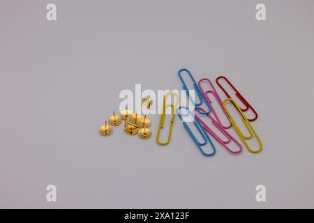 The colorful paper clips and small yellow balls arranged in a row. Stock Photo