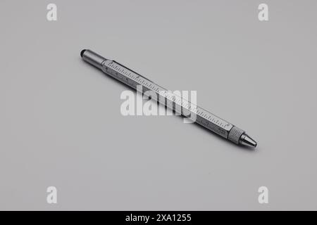 A pen rests on a gray table at an angle Stock Photo