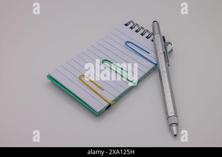 An open notebook with paper and a clipboard placed beside it. Stock Photo