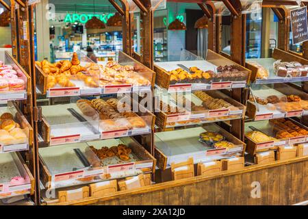 Close-up of various fresh baked goods on display on shelves in a supermarket. Stock Photo