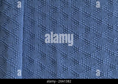 Close-up photography of a navy blue knitted blanket in brocade knitting pattern texture Stock Photo