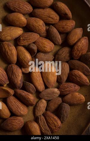 The nuts in a bowl and on a wooden table surface Stock Photo