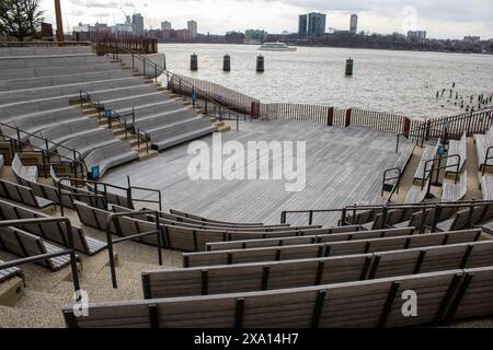 An outdoor concert seating by water with city skyline in the background Stock Photo