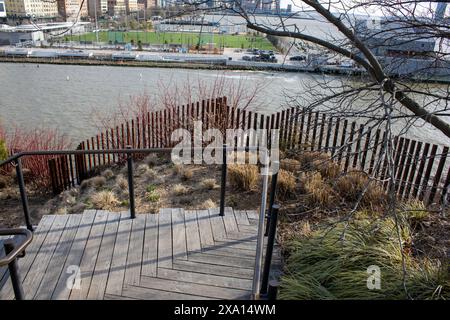 A scenic view of wooden walkway leading to bridge over river Stock Photo