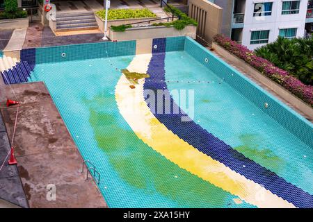 Damaged swimming pool on condominium property. Cleaning and repair of facing tiles. Stock Photo