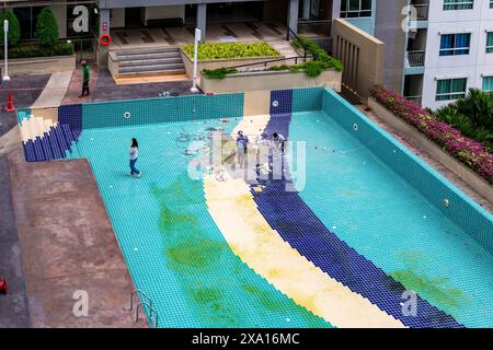 Damaged swimming pool on condominium property. Cleaning and repair of facing tiles. Pattaya, Thailand - 01.23.2024 Stock Photo