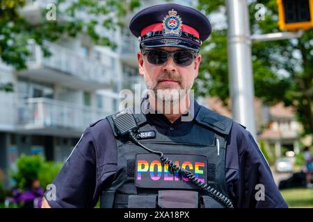 Policing, candid portrait of pride parade OPP policeman wearing pride rainbow colours, LGBT, LGBTQ+ march, London, Ontario, Canada Stock Photo