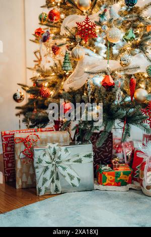 A Christmas tree surrounded by various gifts beautifully wrapped with bows and ornaments, perfect for holiday gift ideas Stock Photo